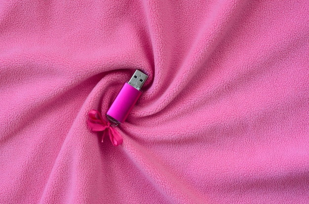 Foto scheda di memoria flash usb brillante rosa con un fiocco rosa