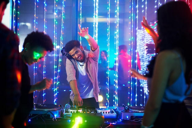 Bringing the beats Portrait of a happy young DJ playing music at a party in a nightclub