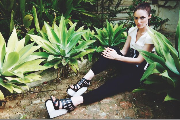 Bringing her personality into the world of nature Full length shot of a beautiful and stylish young woman sitting in the midst of nature