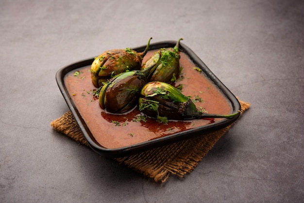 Brinjal curry also known as spicy baingan or eggplant masala, a popular main course recipe from India served in a bowl, karahi or pan