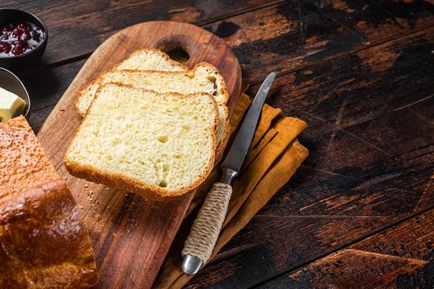 Brioche bread on breakfast table with butter and jam Wooden background Top view Copy space