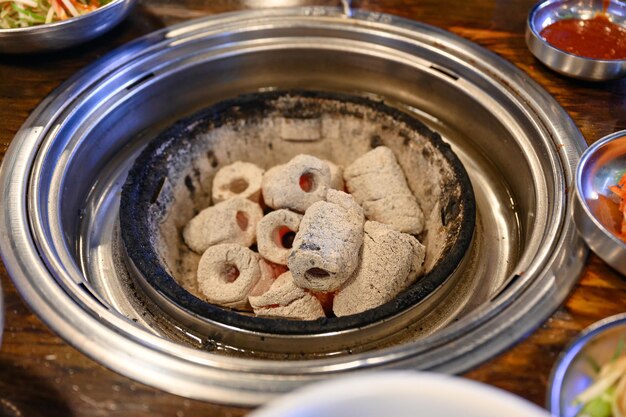 Briquette charcoal burning in stove on grill