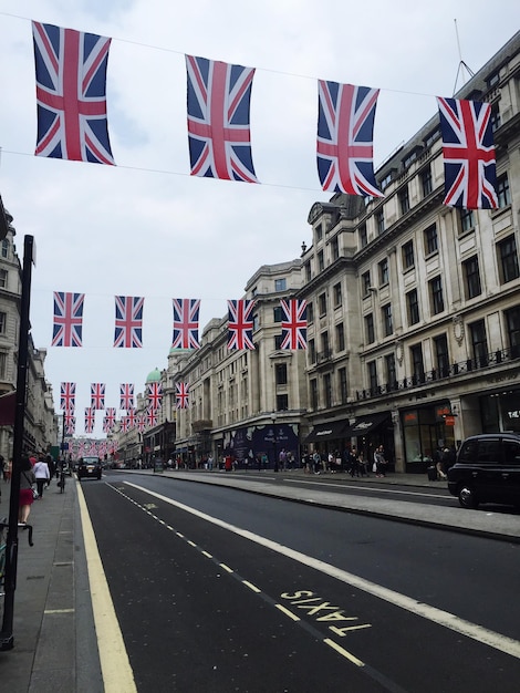 写真 イギリス国旗が雲の空に照らされた道路を渡す