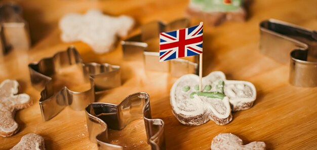 Photo british holiday and christmas baking concept union jack flag of great britain and gingerbread men bi...