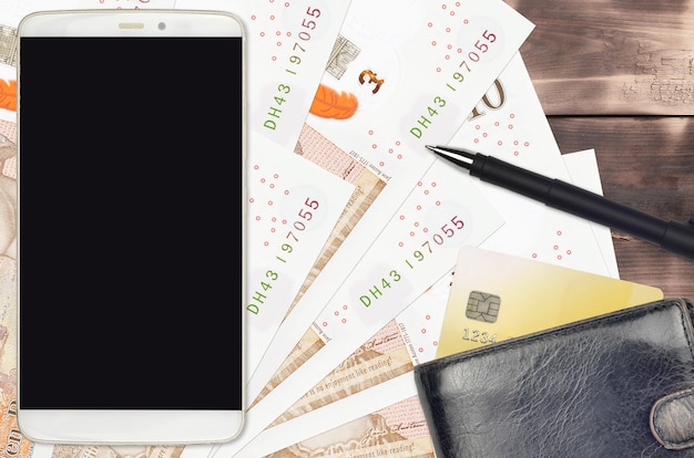 Banconote in sterline inglesi e smartphone con borsa e carta di credito