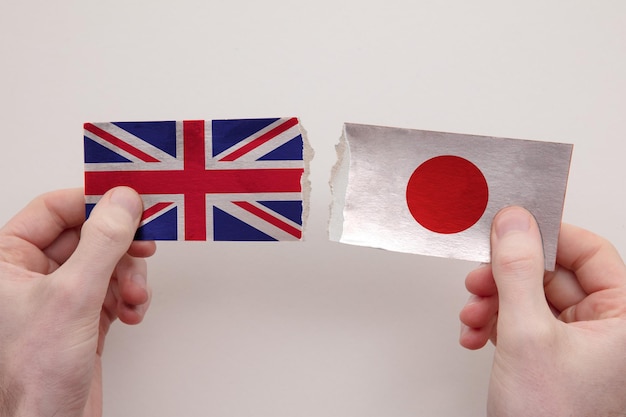 Britse en Japanse papieren vlaggen verscheurd politiek relatieconcept