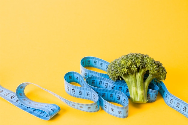 broccoli and blue measuring tape isolated
