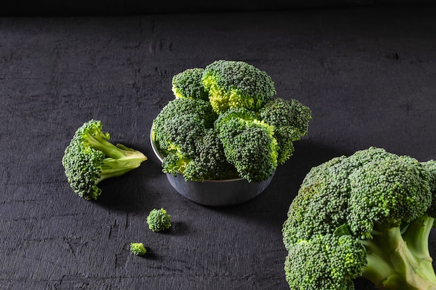 Broccoli in a bowl on a black background.