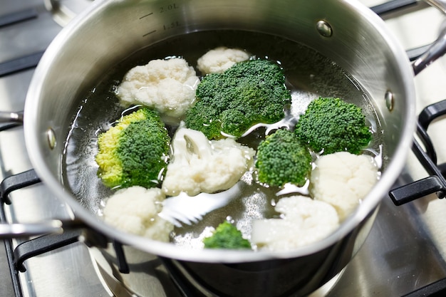 Broccoli and cauliflower boiled in a gray saucepan on a gas stove