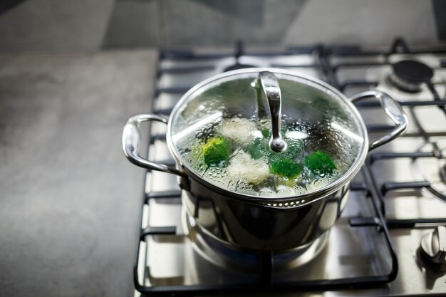 Broccoli e cavolfiori bolliti in una casseruola grigia su un fornello a gas