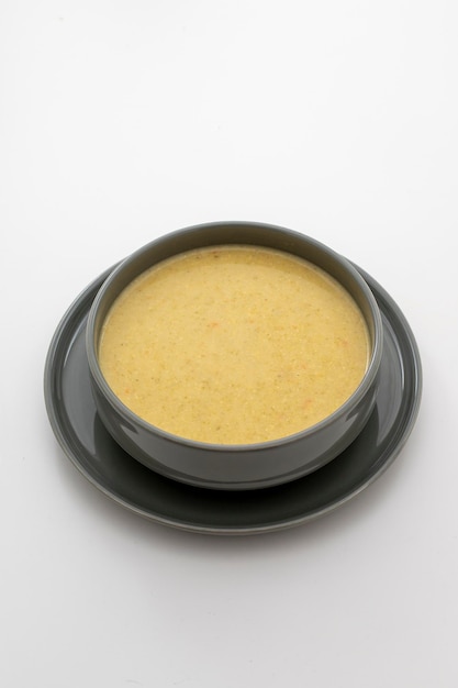 Broccoli cream soup on white background side view