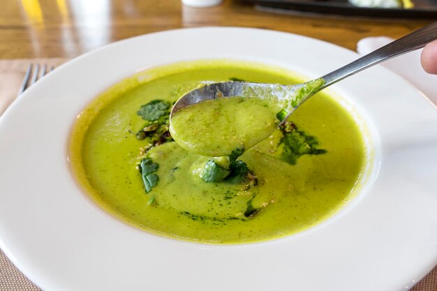 Broccoli cream soup in white plate on wooden