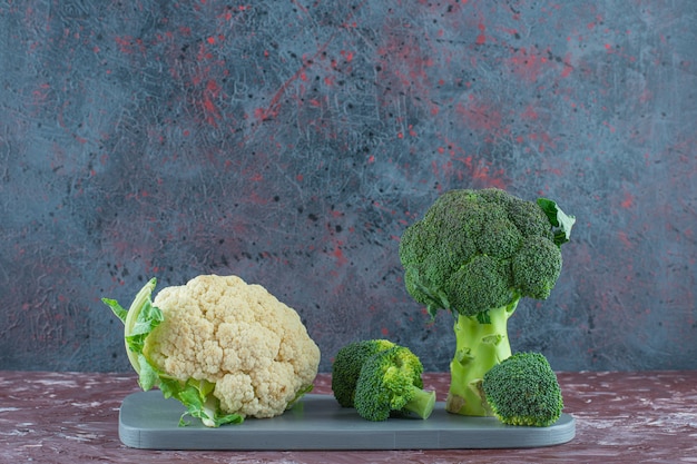 Broccoli en bloemkool op een bord op het marmeren oppervlak