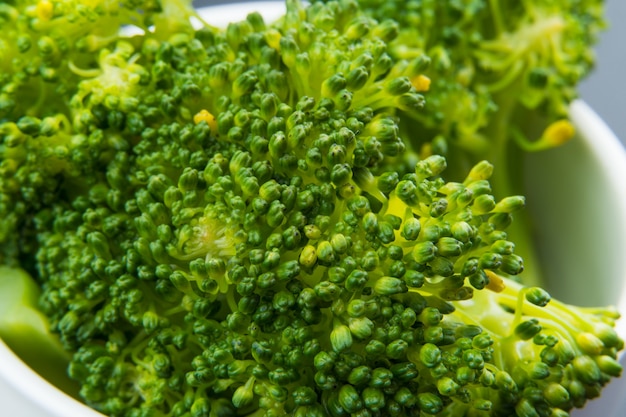 Broccoli in een witte geïsoleerde pot. Selectieve aandacht. Bovenaanzicht. macro.