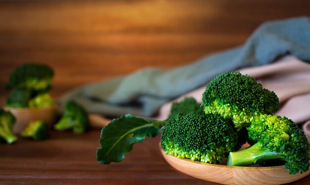 Broccoli op bruine plaat over houten achtergrond.