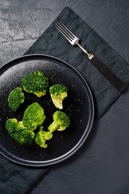 Foto broccoli op een zwarte plaat.