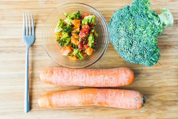 Broccoli salad with carrot in glass bowl