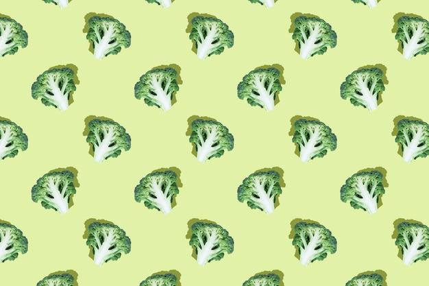 Fette di broccoli su sfondo verde brillante motivo regolare senza cuciture