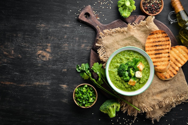 Broccoli, spinach cream soup in a bowl with toasted bread. Green soup. Dietary food. Top view.