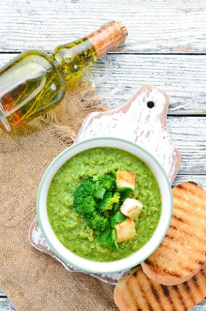 Broccoli spinach cream soup in a bowl with toasted bread Green soup Dietary food Top view