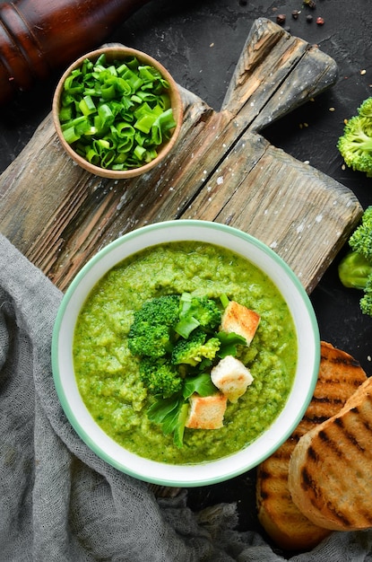 Broccoli spinach cream soup in a bowl with toasted bread Green soup Dietary food Top view