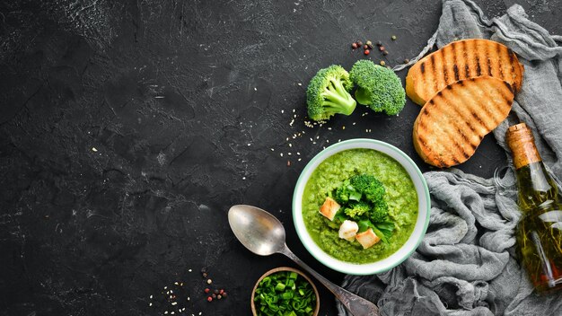 Broccoli spinach cream soup in a bowl with toasted bread Green soup Dietary food Top view