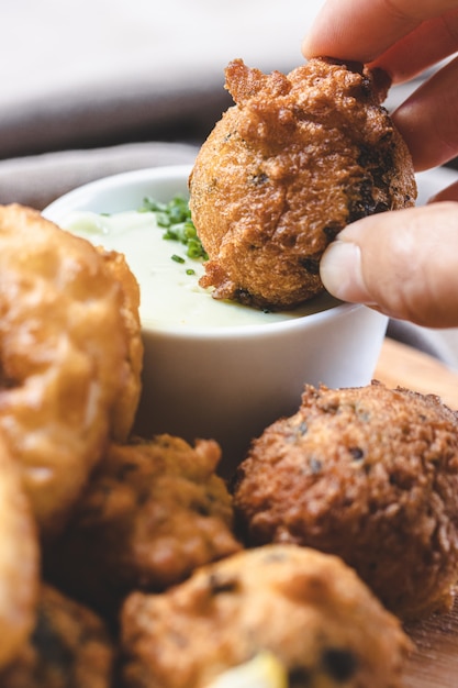 Broccoli, spinach and onion fritters with yogurt dressing with fresh herbs.