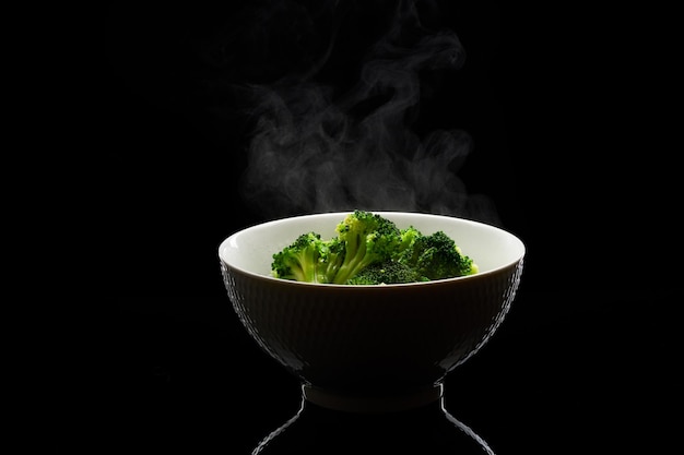 Foto broccoli in una ciotola al vapore su sfondo nero