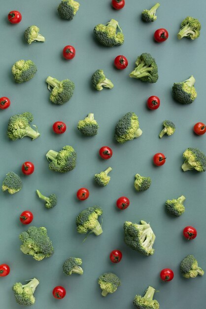 broccoli, tomatoes on green paper background