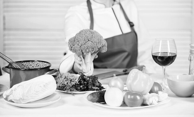 Broccoli voedingswaarde Raw food dieet Vrouwelijke professionele chef-kok houdt rauwe broccoli groente Gratis gezonde vegetarische en veganistische recepten Verander broccoli in favoriet ingrediënt Hoe broccoli te koken