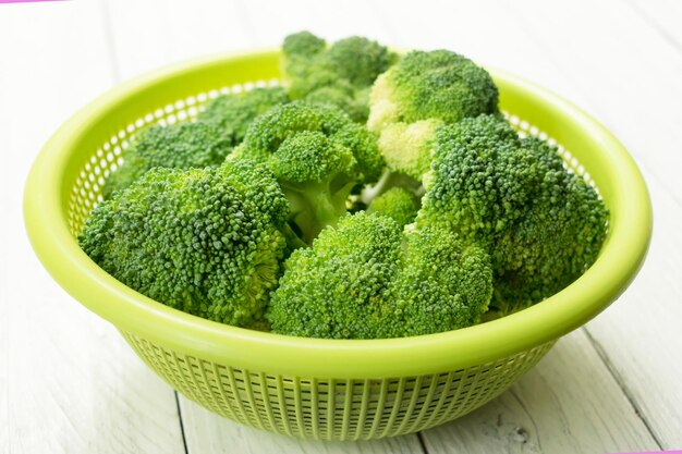 Broccolikool in een bord op een witte houten ondergrond