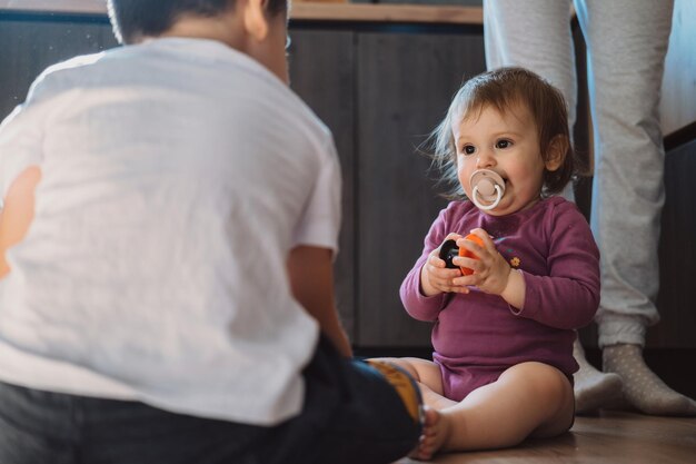 Broer en babyzus spelen met speelgoed op de vloer thuis kinderen spelen familietijd