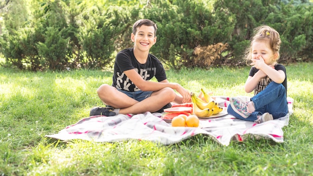 Broer en zus genieten van de picknick in het park