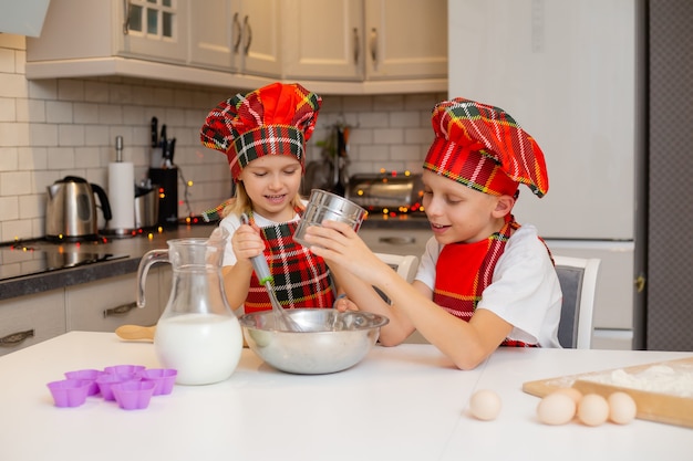 broer en zus koken feestelijke dinerkoekjes in de keuken nieuwjaarswinterconcept