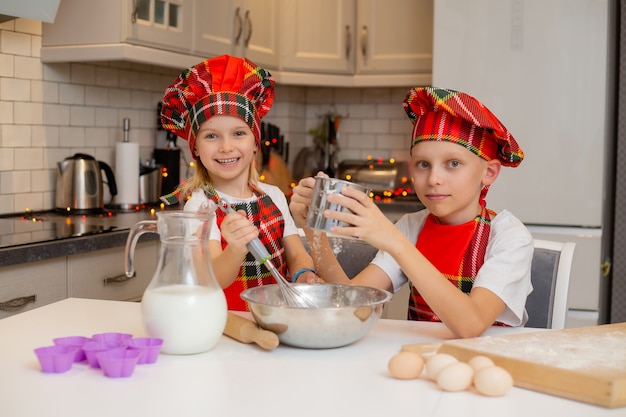 broer en zus koken feestelijke dinerkoekjes in de keuken nieuwjaarswinterconcept