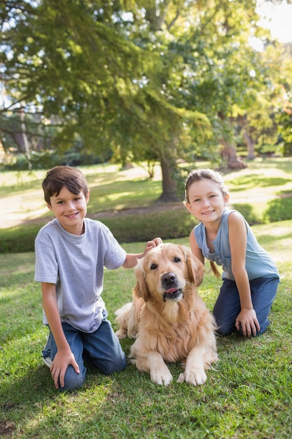 Broer en zus met hun hond in het park