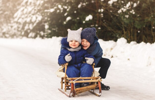 Broer en zus spelen in de winter op straat. Kinderspellen in de natuur