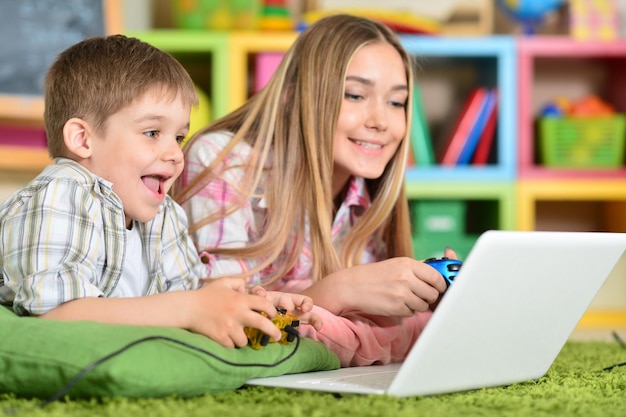 Broer en zus spelen op de computer.