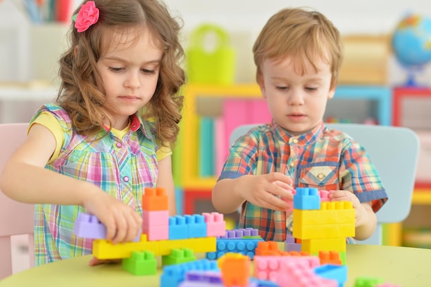 Broer en zus spelen samen met kleurrijke plastic blokken