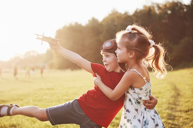 Broer en zus spelen samen. Twee kinderen spelen met een houten vliegtuig buiten