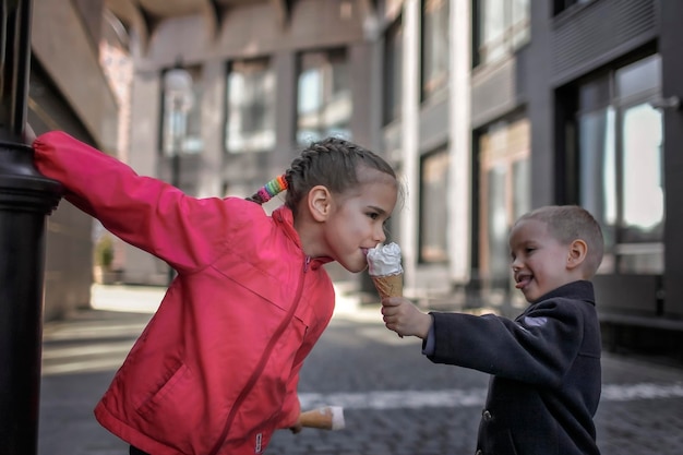 Broer geeft zuster ijs op straat.