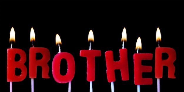 Broer gespeld in rode verjaardagskaarsen tegen een zwarte achtergrond
