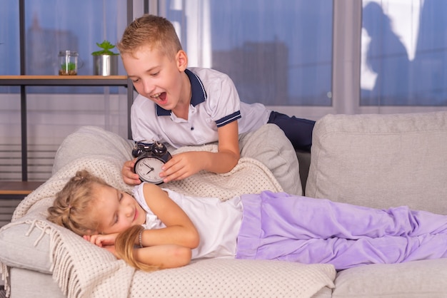 broer maakt zus wakker met wekker belt luid en wil niet opstaan voor school