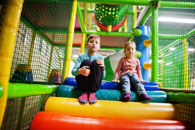 Broer met zus spelen in indoor speelcentrum.