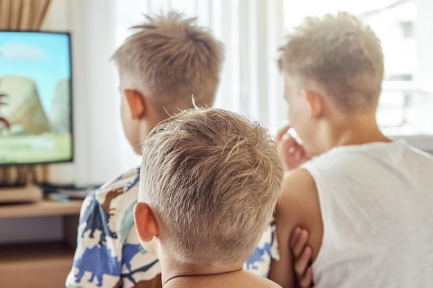 Broers die in een hotelkamer zitten, kijken samen naar tekenfilms op tv