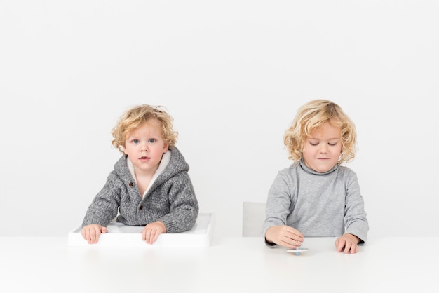 Broers en zussen jongens zitten aan de tafel