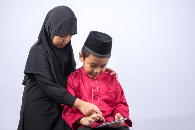 Broers en zussen met een digitale tablet tegen een witte achtergrond