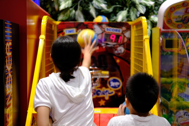 Broers en zussen spelen arcade op de speeltuin.