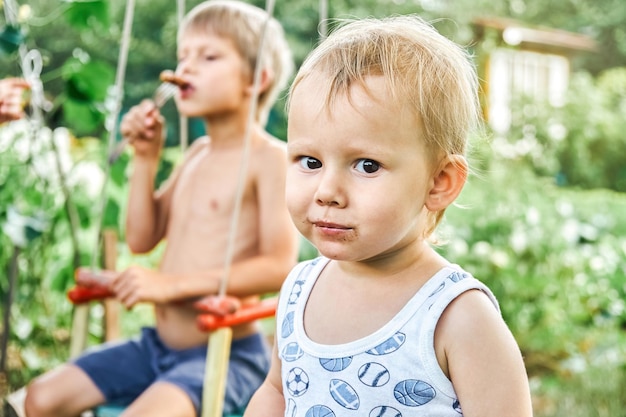 Broers genieten van barbecueworst tijdens een picknick in de natuur met weelderig groen op het platteland