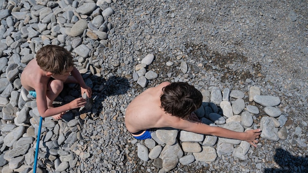 Broers spelen op een kiezelstrand